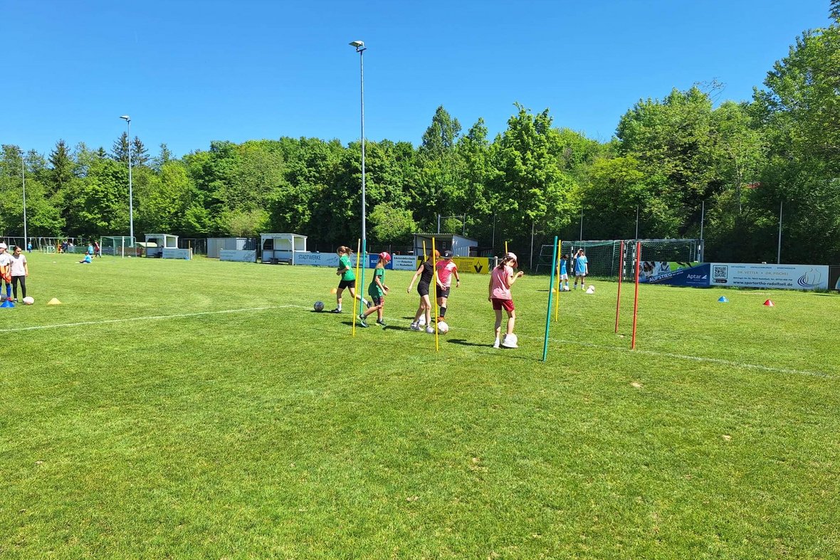 Mädchen dribbeln durch einen Stangenparcours